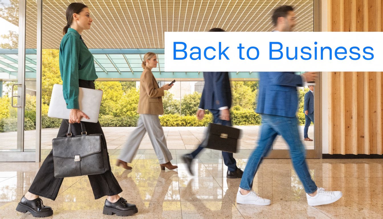 A diverse group of professional office workers walking briskly through a modern glass office building lobby.