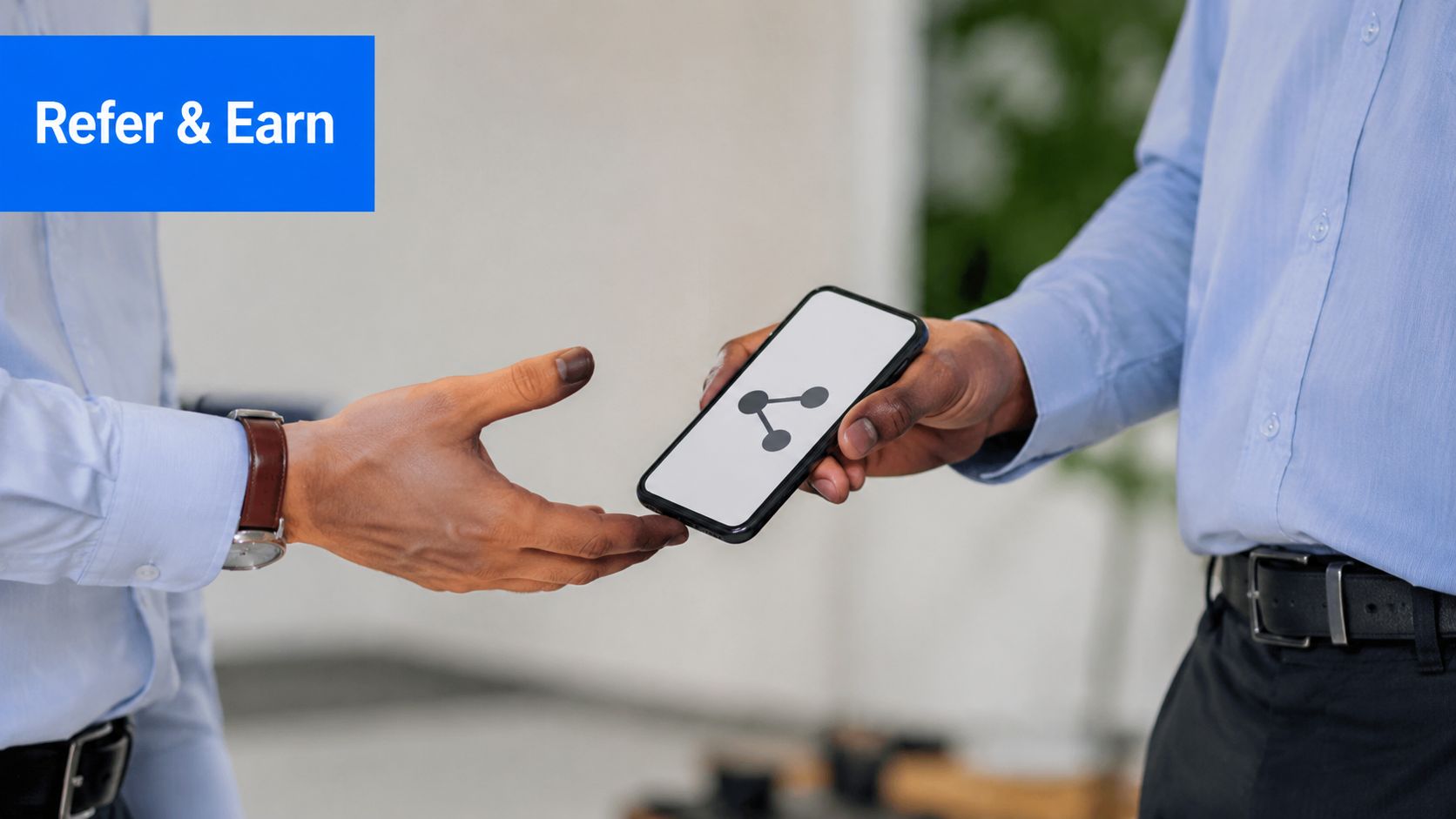 A professional handing a smartphone displaying a sharing icon to another person, representing referral marketing.